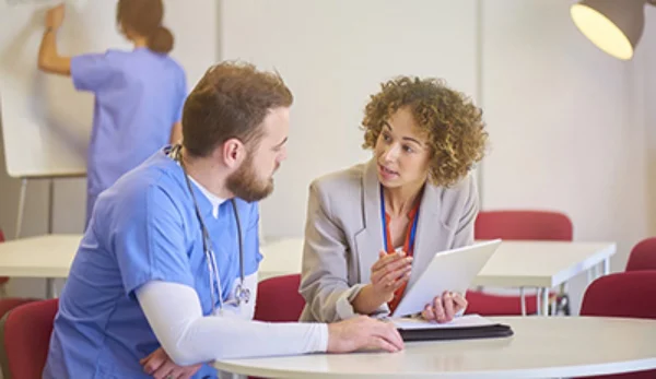 Nursing colleagues having a discussion. UConn Online Nursing Graduate Degree Programs.